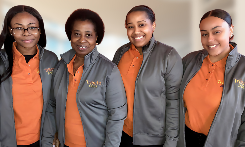 4 Tribute Caregivers smiling wearing Tribute Home Care uniforms