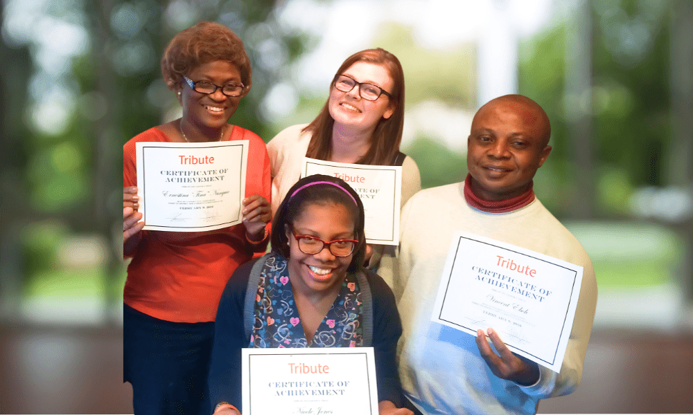 4 Tribute Caregivers smiling and holding up Certificates of Achievement