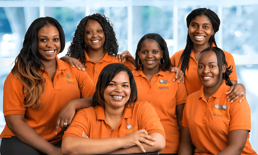 6 Tribute Caregivers smiling in Tribute Home Care uniforms