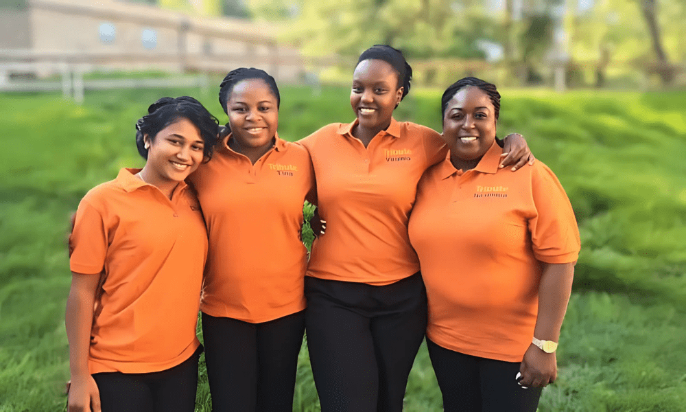 4 Tribute Caregivers smiling in Tribute Home Care uniforms outside