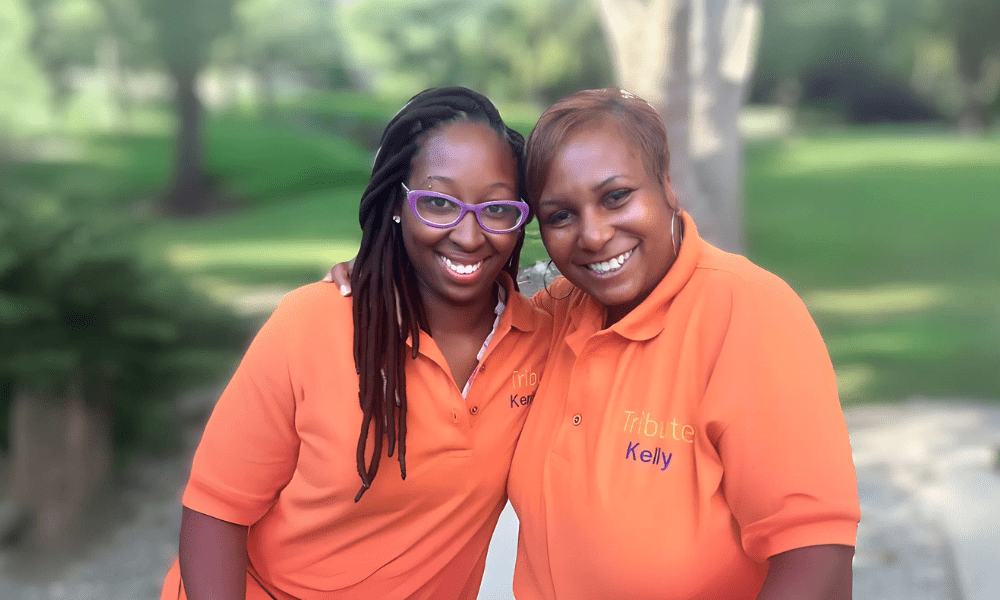 2 Tribute Caregivers smiling in Tribute Home Care uniforms