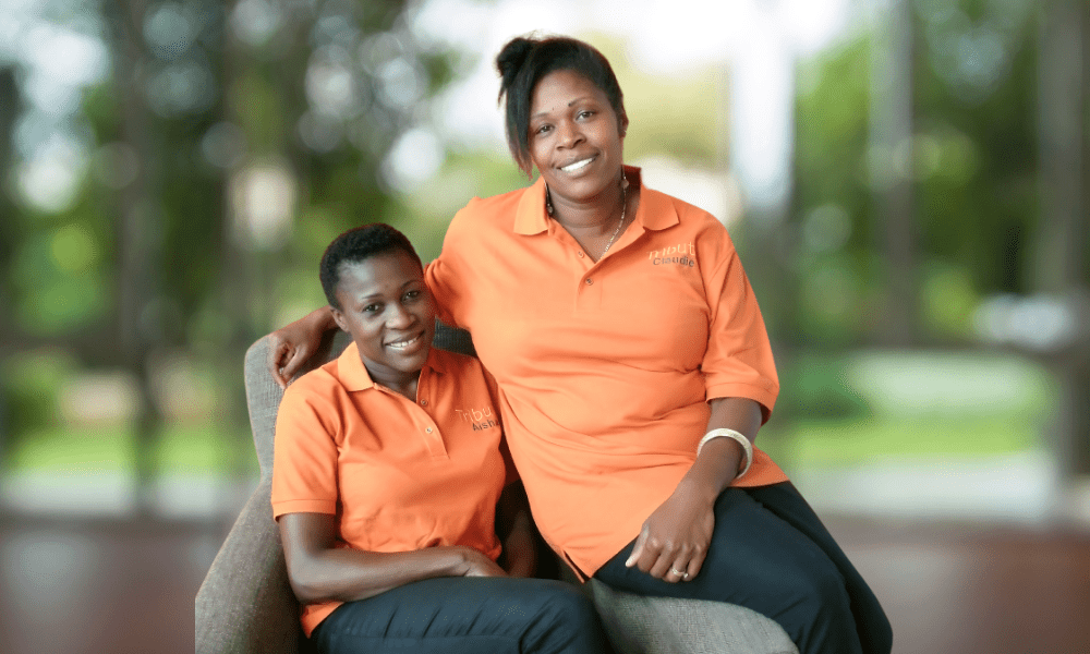 2 Tribute Caregivers smiling in Tribute Home Care uniforms