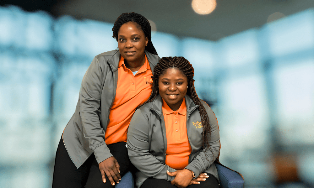 2 Tribute Caregivers smiling in Tribute Home Care uniforms