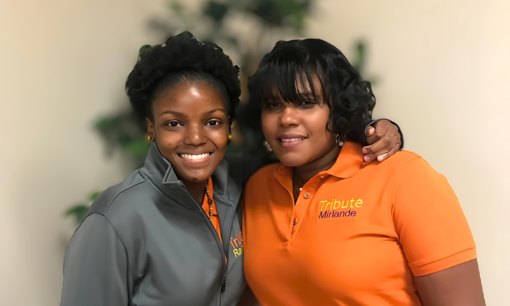 2 Tribute Caregivers smiling in Tribute Home Care uniforms