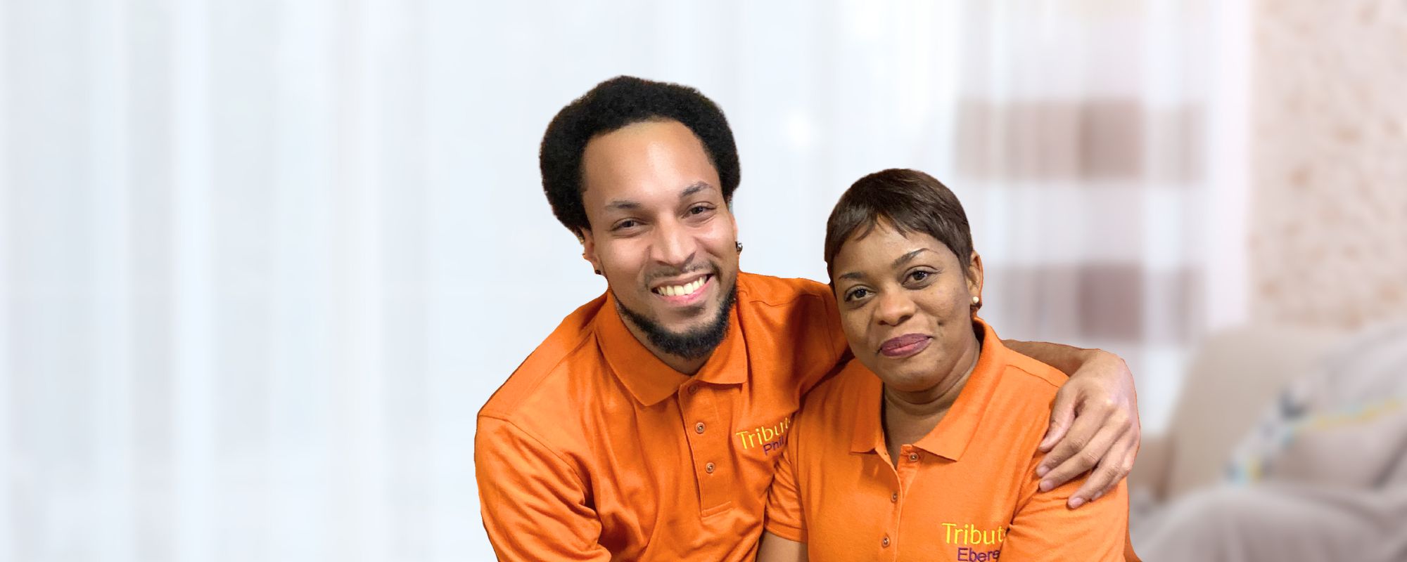 2 Tribute Caregivers Phil and Ebere smiling in Tribute Home Care uniforms