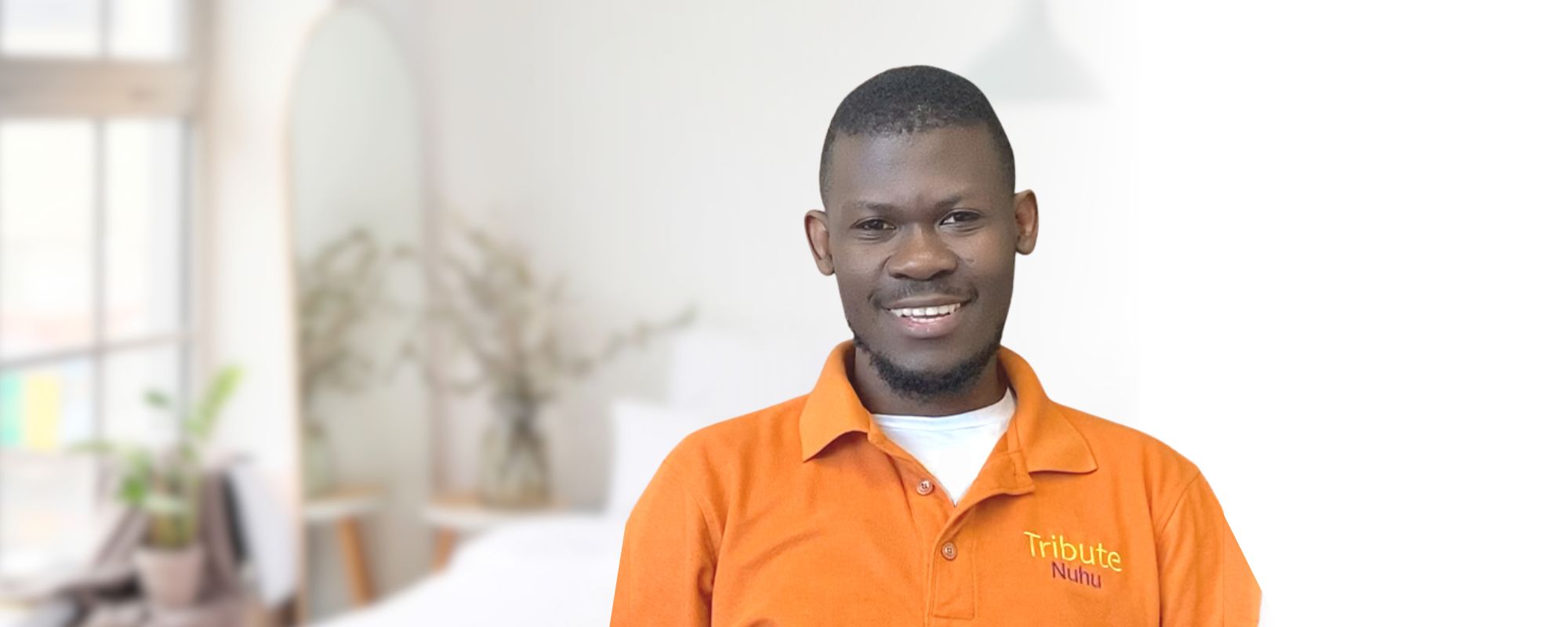 Tribute Caregiver Nuhu smiling in Tribute Home Care uniform