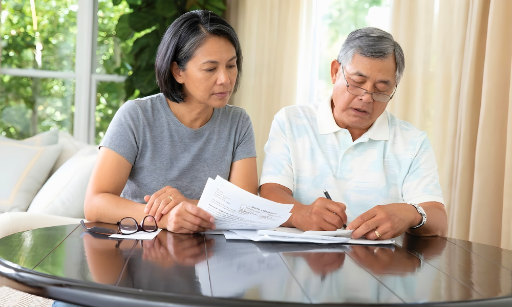 Older couple reviewing home care cost and payment documents together at a table